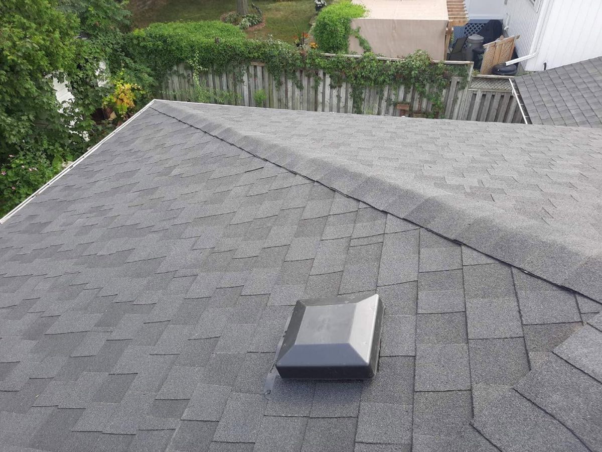 Grey shingle roof with a roof vent and eavestrough along the lower edge