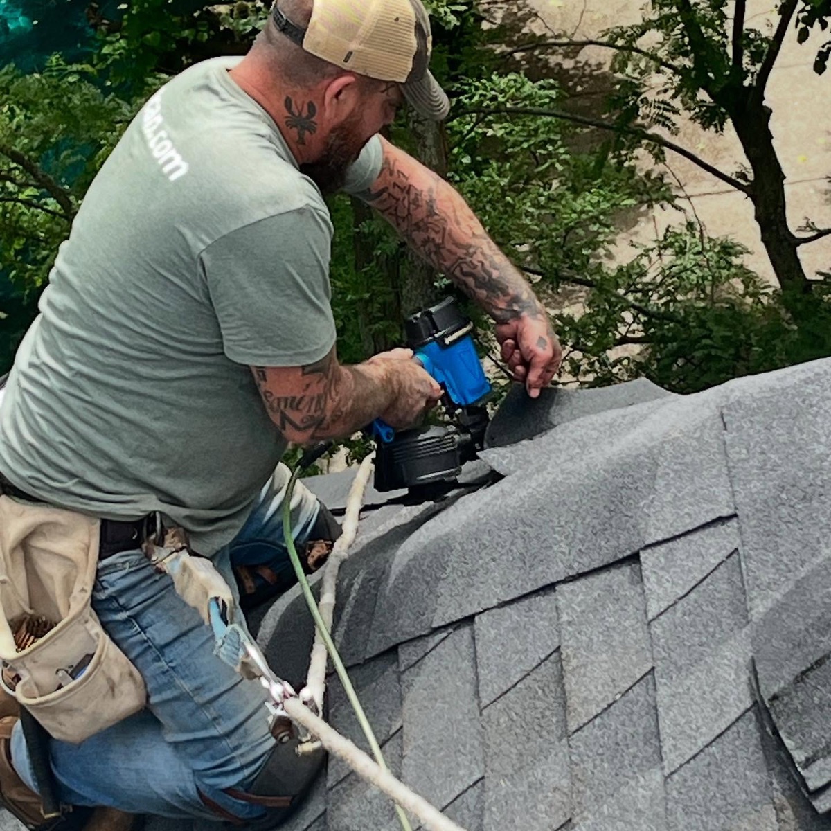 Beaudry roofer hand-nailing ridge-cap shingles with a coil nailer