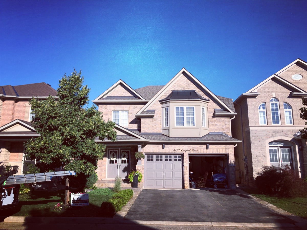 Large two-storey brick home with a completed new shingle roof